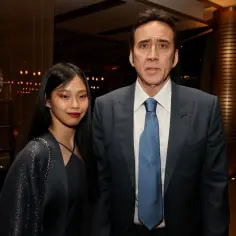 Nicolas Cage w garniturze i jego żona w ciemnej sukience i błyszczącym narzutce.