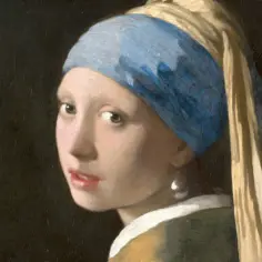 Dziewczyna z perłą, w błękitnym turbanie, spogląda tajemniczo. Jej spojrzenie i błyszcząca perła przyciągają uwagę.