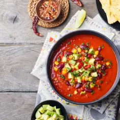 Prawdziwa zupa meksykańska z fasolą, kukurydzą i awokado, podana z nachos.