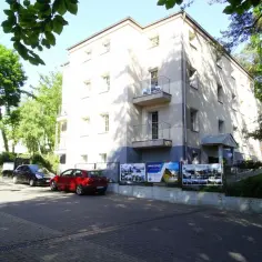 Nowa Fregata Pokoje i Apartamenty: budynek z balkonami, parking z samochodami i zielone drzewa.