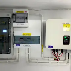 Instalacja fotowoltaiczna z falownikiem Sunways, rozdzielnicami i zabezpieczeniami. System przetwarza energię słoneczną, magazynując energię chemiczną w akumulatorach.