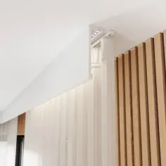 Nowoczesny karnisz w zabudowie z oświetleniem LED, ukryty za białą listwą, idealnie komponuje się z drewnianą boazerią i zwiewnymi zasłonami.