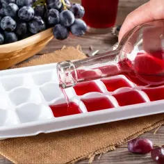 Wino przelewane do pojemnika na lód, by zamrozić je do celów kulinarnych. Skutki mrożenia wina w zamrażarce są widoczne na zdjęciu.