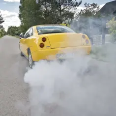Żółty Fiat Coupe z charakterystycznym dymem z opon. Czy to **upg co to** za wyczyn?