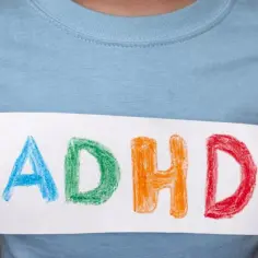 Dziecko trzyma kartkę z napisem ADHD. Czy medikinet ma skutki uboczne?