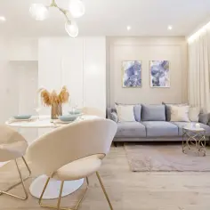 Nowoczesny salon z jadalnią, gdzie subtelne oświetlenie LED tworzy przytulną atmosferę. Jasne meble i pastelowe dodatki.