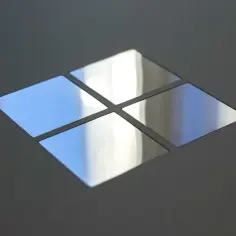 Cztery lustrzane kwadraty tworzą symbol Windows. Widać odbicia nieba i światła.
