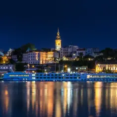 Nocny Belgrad z rzeką i statkiem wycieczkowym. Czy do Serbii potrzebny jest paszport? Sprawdź przed podróżą!