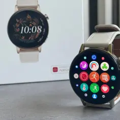 Elegancki Huawei Watch GT 3 z jasnym paskiem i kolorowymi ikonami aplikacji na ekranie. Obok stoi pudełko zegarka.