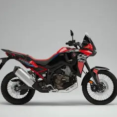 Czerwono-czarny motocykl Honda Africa Twin 1100, gotowy na przygodę. Szczegółowe honda africa twin 1100 dane techniczne dostępne dla każdego podróżnika.