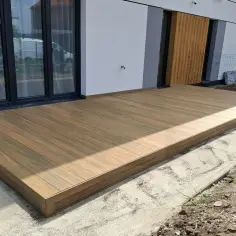 Nowy taras na słupach betonowych, wykonany z desek kompozytowych, czeka na zagospodarowanie otoczenia.