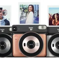 Trzy aparaty Instax SQ 6 w różnych kolorach, z których wychodzą zdjęcia z uśmiechniętymi ludźmi.
