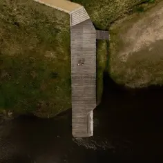 Drewniany pomost nad rzeką, z dwoma osobami, to jedna z atrakcji Nowego Korczyna.