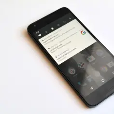 Czarny smartfon z powiadomieniem o pobraniu aktualizacji systemu Android 7.0 Nougat.