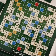 Plansza do gry Scrabble z ułożonymi polskimi słowami i literami.