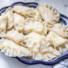 Talerz pełen pysznych, domowych pierogów. Zastanawiasz się, ile wychodzi pierogów z 1kg mąki? Oto odpowiedź na talerzu!