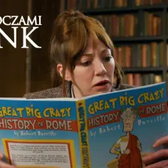 Kobieta z zaciekawieniem czyta książkę "Great Big Crazy History of Rome", jakby odkrywała świat oczami Cunk.