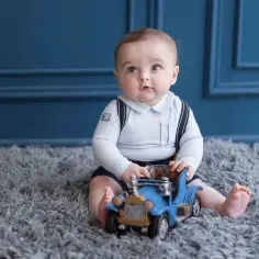 Uroczy chłopiec z zabawką-autkiem na roczek. Ciekawe, ile dziadkowie dadzą na roczek?
