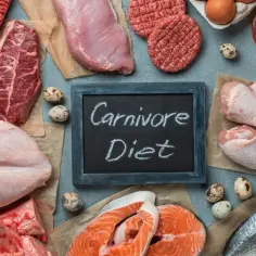 Różnorodne mięsa, ryby i jaja ułożone wokół tabliczki z napisem "Carnivore Diet".