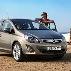 Opel Corsa, idealne auto do 20 tys. na wakacyjny wypad nad morze. Para odpoczywa na plaży przy łodzi.