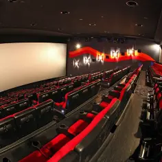 Puste rzędy czerwonych i czarnych foteli kinowych w Cinema City. Zastanawiasz się, ile zarabia się w Cinema City?