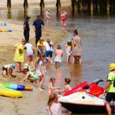 Na plaży nad jeziorem Jamno widać ratowników WOPR i bawiące się dzieci. Czy można się kąpać? Tak, woda wygląda na spokojną.