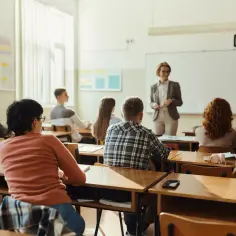 Uczniowie siedzą w ławkach, słuchając nauczycielki. Czy po zawodówce ma się wykształcenie średnie? To pytanie nurtuje wielu młodych ludzi.