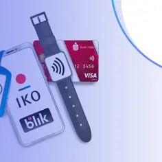 Smartfon z aplikacją IKO, karta płatnicza i smartwatch na tle logo PKO Banku Polskiego.