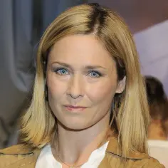 Beata z klanu, z niebieskimi oczami i blond włosami, patrzy wprost na widza.