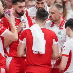 Drużyna siatkarzy Polski w czerwonych strojach, trener udziela wskazówek. Czy to kluczowy moment w walce o mistrzostwa świata siatkówka tabela?