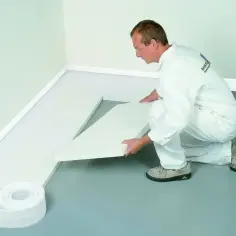 Pracownik układa biały styropian na podłogę, tworząc izolację. To dobry wybór, jeśli zastanawiasz się, jaki styropian na podłogę wybrać.