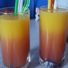 Dwa drinki z soplicy malinowej, warstwowe, z kolorowymi słomkami. Idealne na letnie popołudnie.