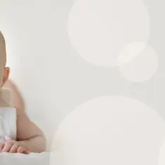 Zaskoczony 4-miesięczne dziecko skok rozwojowy, z szeroko otwartymi ustami i oczami, leży na brzuchu.
