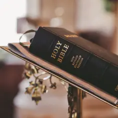 Czarna Biblia na ozdobnym stojaku, symbol wiary i katolicyzmu, gotowa do odczytania.