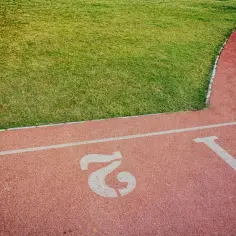 Tor lekkoatletyczny z numerami torów 1, 2, 3 i zieloną trawą. Zastanawiasz się, jaki jest dobry czas na 5 km?