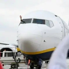 Pilot macha z kabiny samolotu. Zastanawiasz się, ile trwa lot na Sycylię?