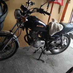 Czarny motocykl Suzuki GN125, gotowy do jazdy. Dane techniczne tego modelu są imponujące.