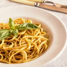 Pyszne linguini z pesto i świeżą bazylią, gotowe do zjedzenia.