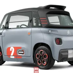 Szary Citroen Ami z pomarańczowymi akcentami i numerem "2" na drzwiach. Ten elektryczny pojazd miejski wyróżnia się futurystycznym designem.