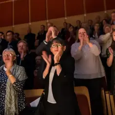 Widownia klaszcze na stojąco w Teatrze Sabat. Eleganckie stroje, jak się ubrać na spektakl.
