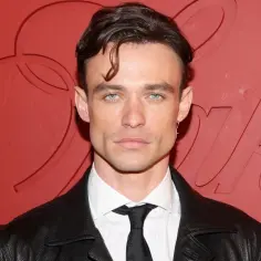 Thomas Doherty, znany z filmów, seriali i programów, prezentuje się w skórzanej kurtce i eleganckiej koszuli.