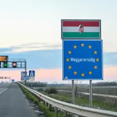 Pusta jezdnia prowadzi do granicy Węgier, oznaczonej flagą i tablicą Unii Europejskiej.