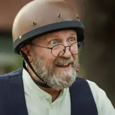 Artur Barciś w kasku i okularach, z siwą brodą, wygląda jakby właśnie skończył kręcić scenę do jednego ze swoich filmów.