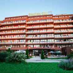 Hotel Gladiola Star z wieloma balkonami i oknami, otoczony zielenią, zaprasza na wakacje.