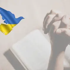 Gołąb pokoju w barwach Ukrainy nad złożonymi do modlitwy dłońmi. Nadzieja na pokój na Ukrainie.