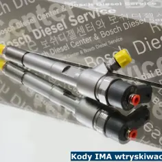 Dwa wtryskiwacze Bosch z żółtymi kapturkami na tle opakowania z logo Bosch Diesel Service. Kody IMA wtryskiwaczy Bosch.