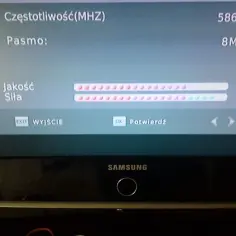 Ekran telewizora pokazuje jak sprawdzić siłę sygnału TV. Widoczne są wskaźniki jakości i siły sygnału, częstotliwość 586.0 MHz i pasmo 8M.