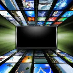 Ekran telewizora otoczony taśmami filmowymi z różnymi obrazami. Czy można oglądać tv bez anteny? Tak, dzięki streamingowi!