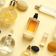 Eleganckie flakoniki perfum damskich, tworzące kompozycję przypominającą ranking. Różnorodne kształty i kolory płynów.