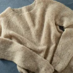 Beżowy, miękki sweter z wełny. Poznaj sekrety prania wełnianych swetrów, żeby nie skurczyły się i nie zmechaciły.